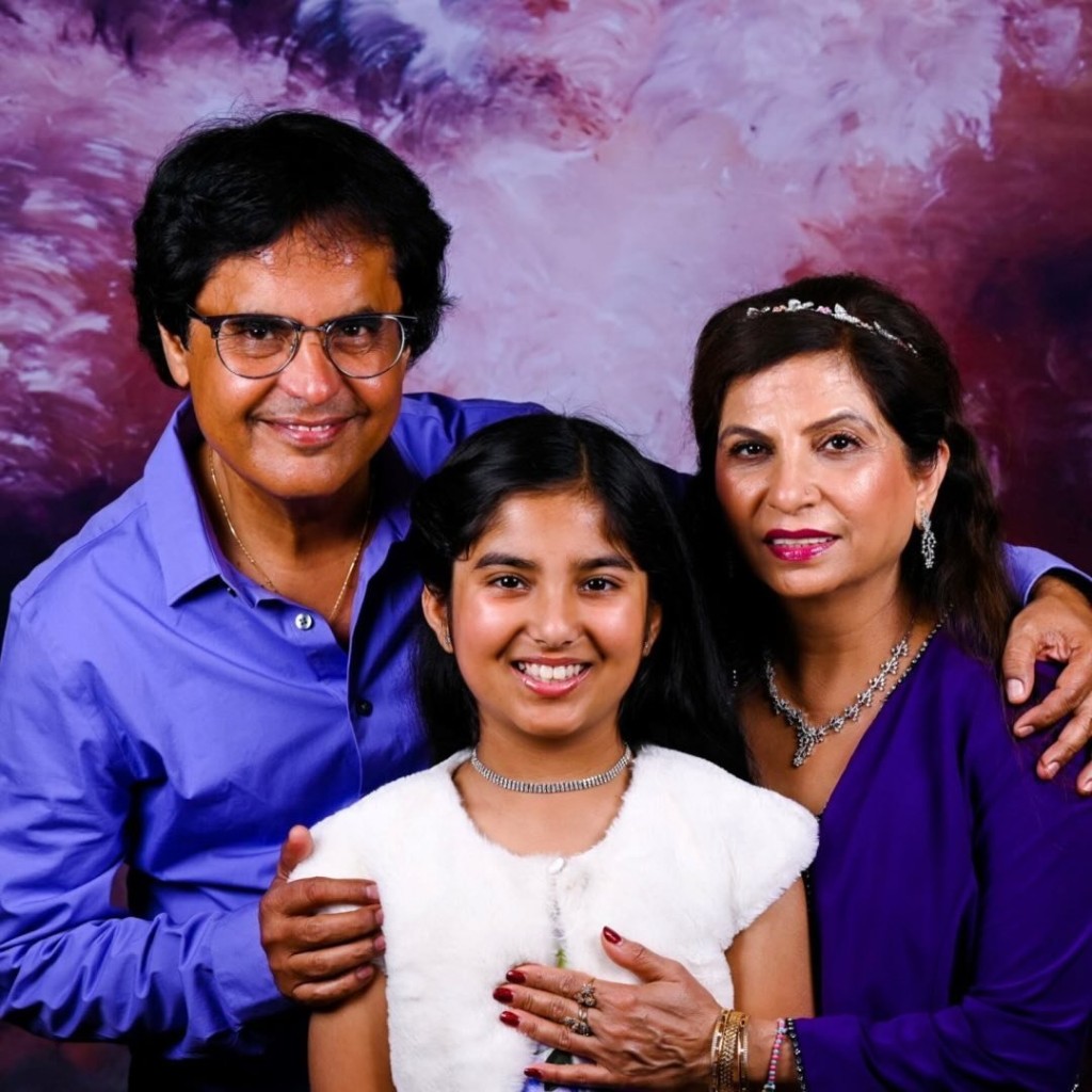 The Aida Grey family — smiling portrait against a soft purple studio backdrop