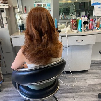 Voluminous auburn waves styled with a professional blowout
