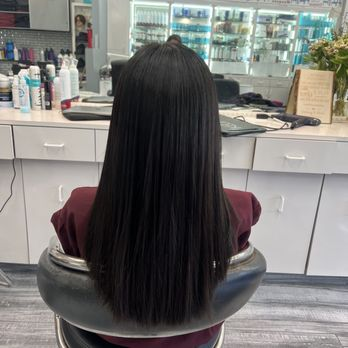 Long, sleek dark hair with glossy finish after a salon cut and style